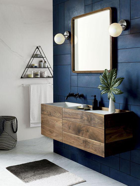ความหนักแน่นของสีน้ำเงิน บวกกับความนุ่มนวลของสีจากธรรมชาติอย่างไม้ ทำให้การออกแบบห้องน้ำ Modern สวยกลมกล่อมมากขึ้น