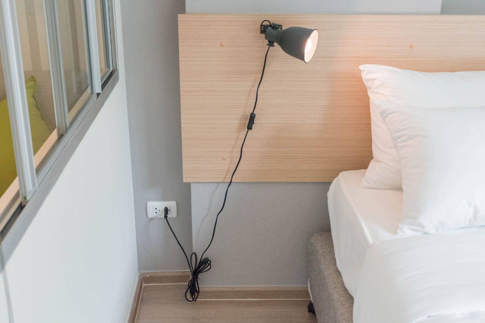 ฝั่งหัวเตียงที่ติดกับห้องนั่งเล่นจะมีปลั๊กไฟเอาไว้ให้ค่ะ ตรงนี้จะใช้เสียบโคมไป หรือเสียบชาร์ตมือถือก็ได้ค่ะ